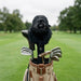 Black gorilla headcover on a golf club with a golf bag on a golf course
