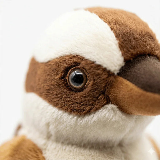Close-up of a brown and white plush bird with detailed eye and soft fur texture