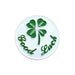 Circular object with a four-leaf clover and 'Good Luck' text on a white background