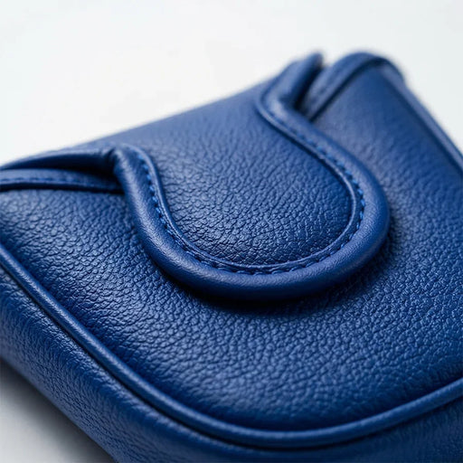 A close-up of a textured blue leather pouch or wallet with a curved top detail, photographed on a clean white background.