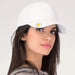 Woman wearing a white cap with a sun flower design ball marker hat clip on a white background