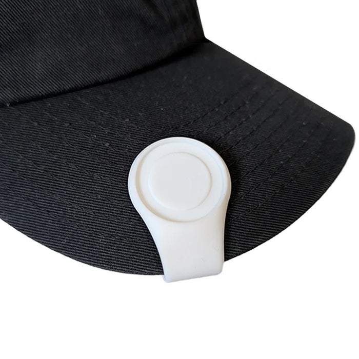 Black cap with a white clip on a white background