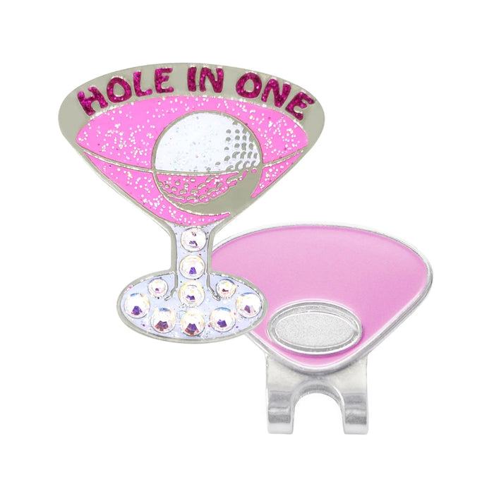 A pink and silver golf accessory shaped like a martini glass, featuring the words 'HOLE IN ONE' in glittery pink lettering and a silver golf ball graphic, shown alongside a matching pink and silver magnetic clip on a white background.