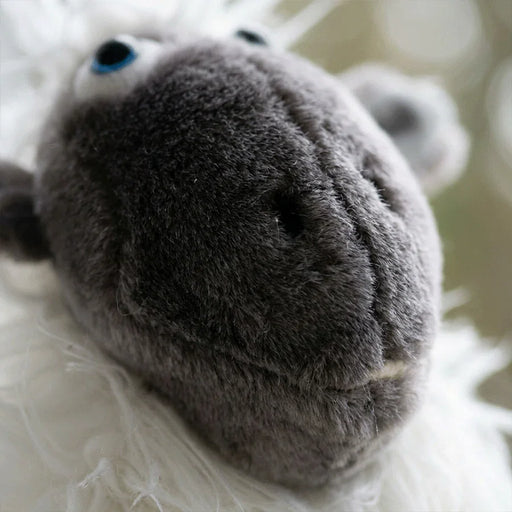 Close-up of a plush sheep headcover with a blurred background