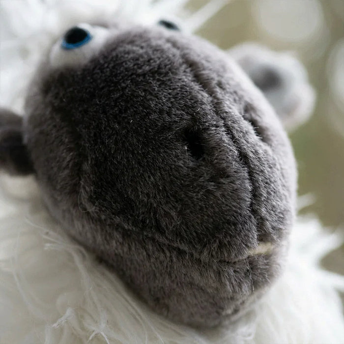 Close-up of a plush sheep headcover with a blurred background