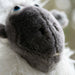 Close-up of a plush sheep headcover with a blurred background